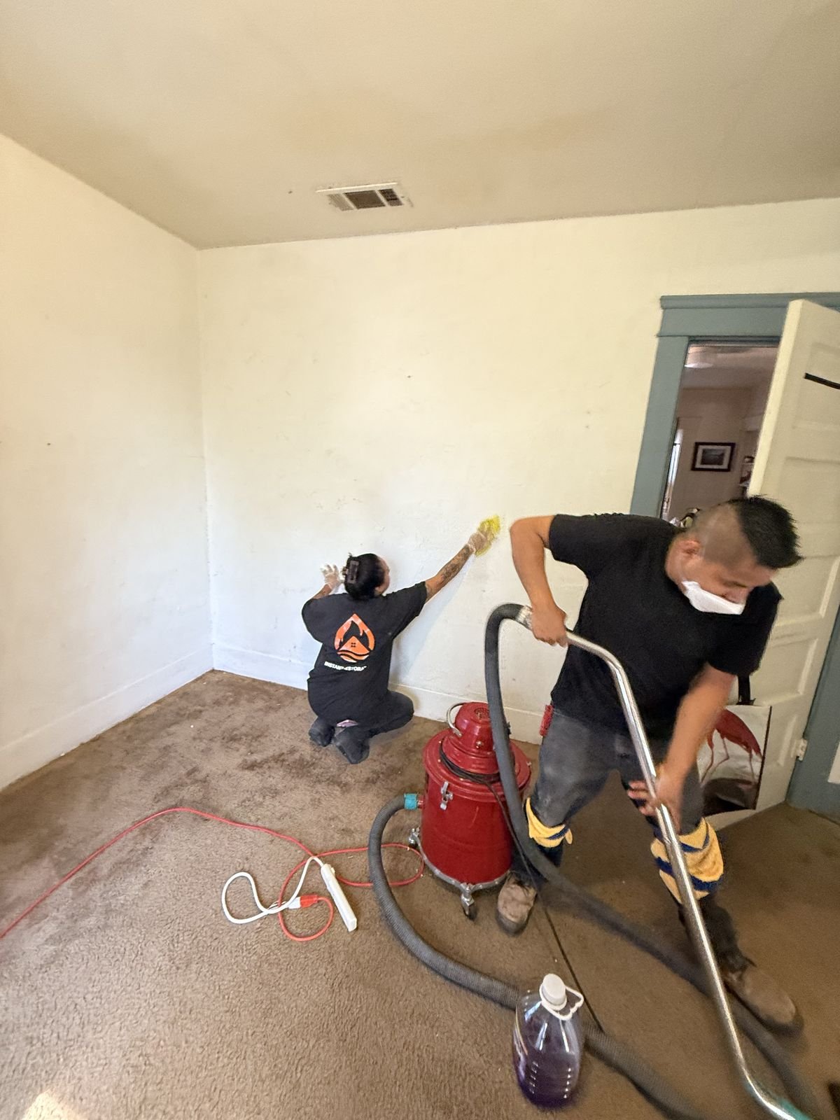 Instant Restoration crew HEPA-vacuuming carpet and dry-sponging walls during smoke damage cleanup - Camarillo, CA