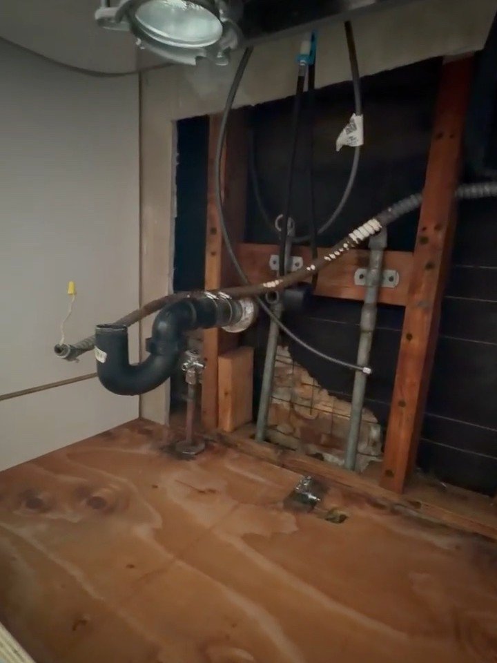 Wall opened to the framing and plumbing during mold remediation to reach the moisture source — Woodland Hills, CA.