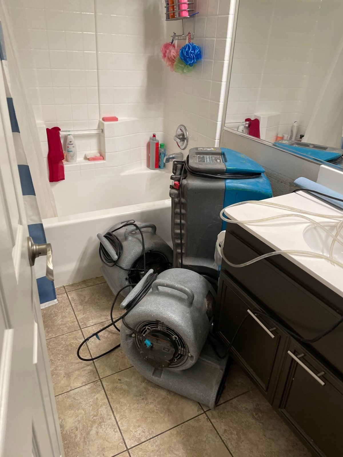 Two air movers and a dehumidifier set up to dry a bathroom after water damage - Agoura Hills, CA