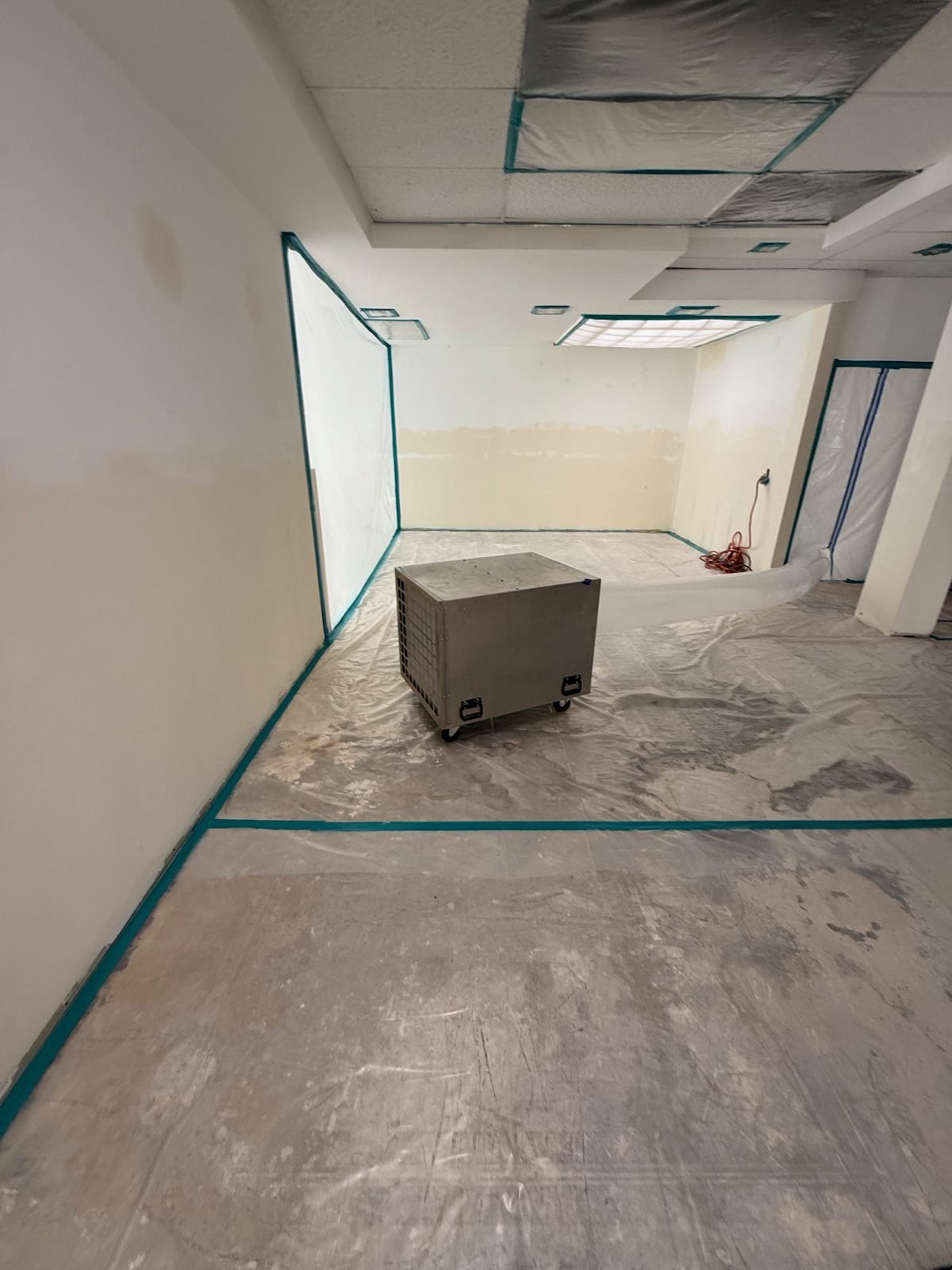 Instant Restoration job photo in Malibu, CA: Commercial space: poly containment walls, taped floor, dehumidifier, ceiling opened