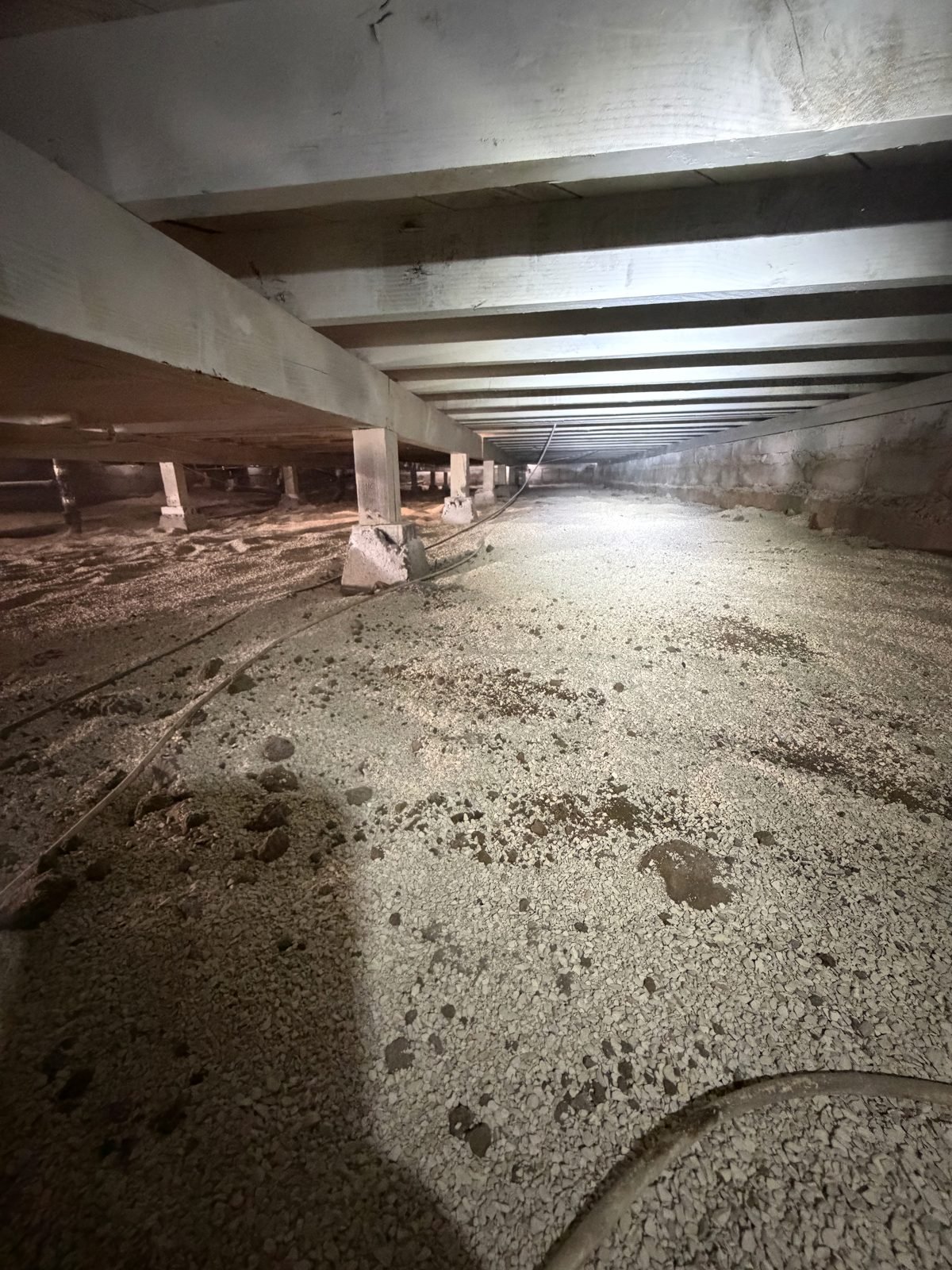 Crawl space under a house: floor framing on concrete piers over a gravel-covered soil floor - Culver City, CA