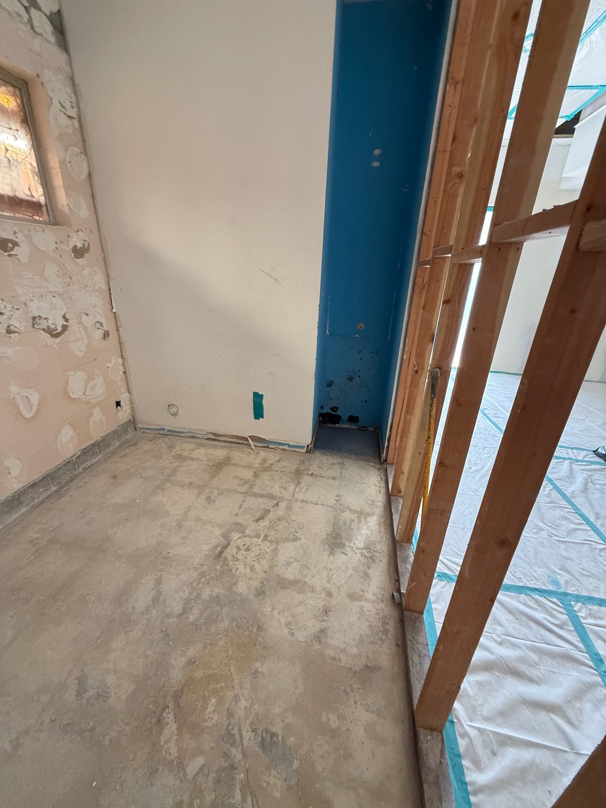 Room gutted to studs and bare slab with containment in place, ready for drying and rebuild - Malibu, CA