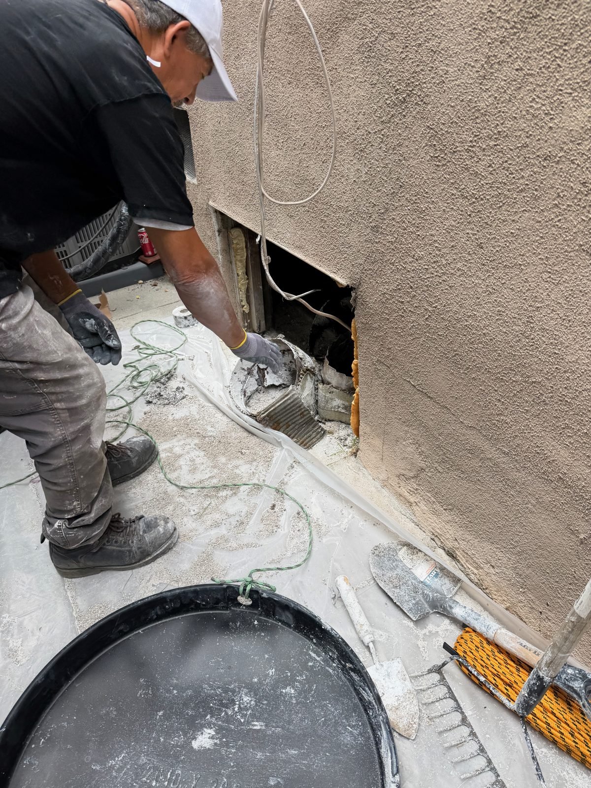Instant Restoration job photo in Beverly Hills, CA: Technician cutting open exterior stucco wall to access cavity; head out of frame